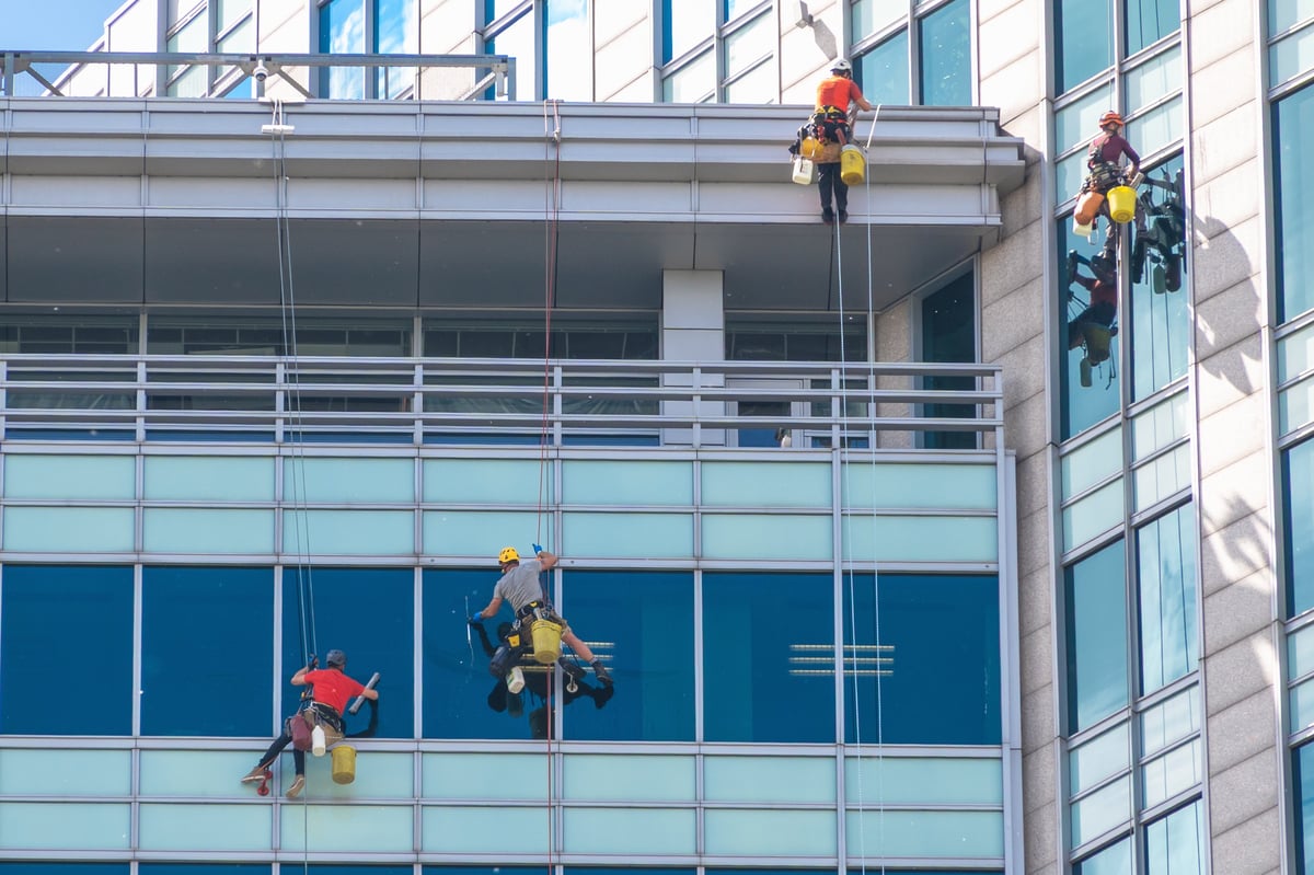 Professional window cleaning team working on a high-rise glass facade