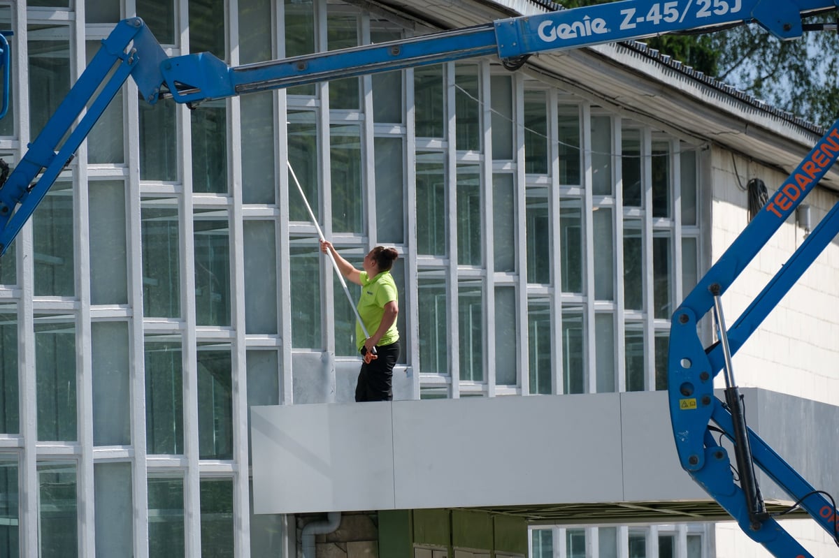 Maintenance professional cleaning the glass facade of a modern building